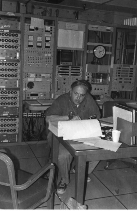 Man seated at table in control room